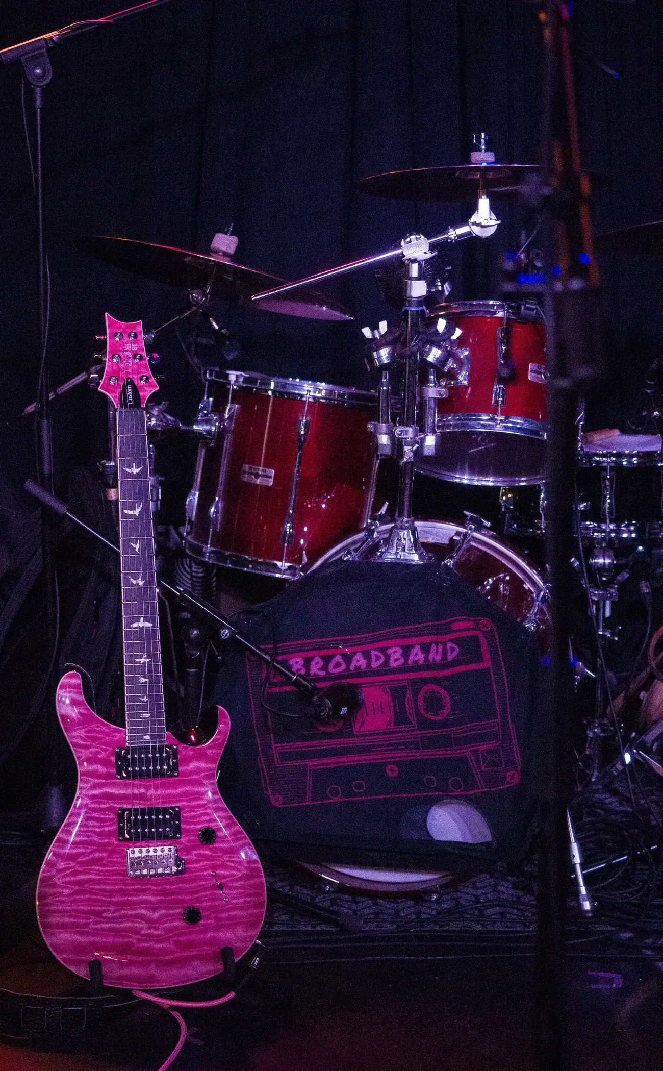 Broadband's stage setup — pink guitar and the cassette logo on the kick drum
